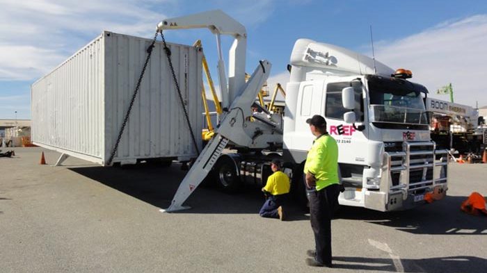 Image of side loader in action unloading a 40ft sea container
