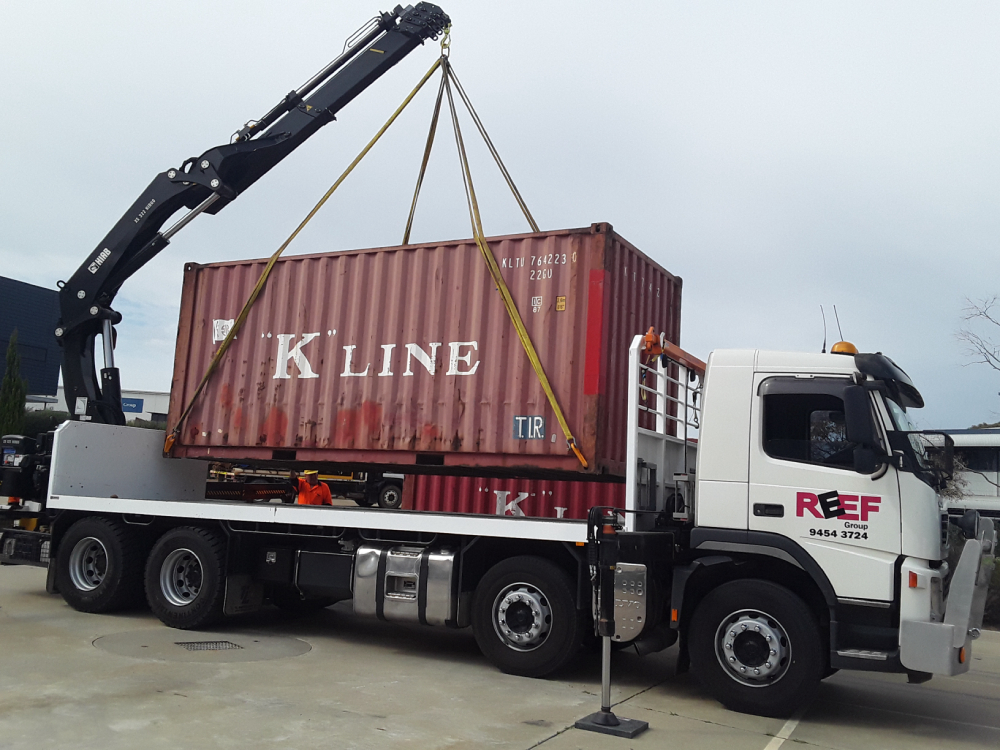 Sea container being dropped onto hiab truck